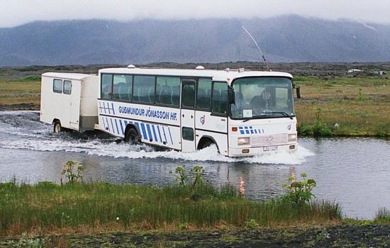 Our cross-country bus with the kitchen trailer during crossing a river