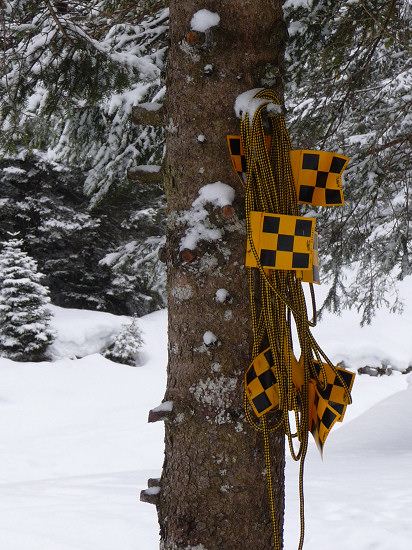 Yellow-black flags on a rope to rope of the way at avalanche risk